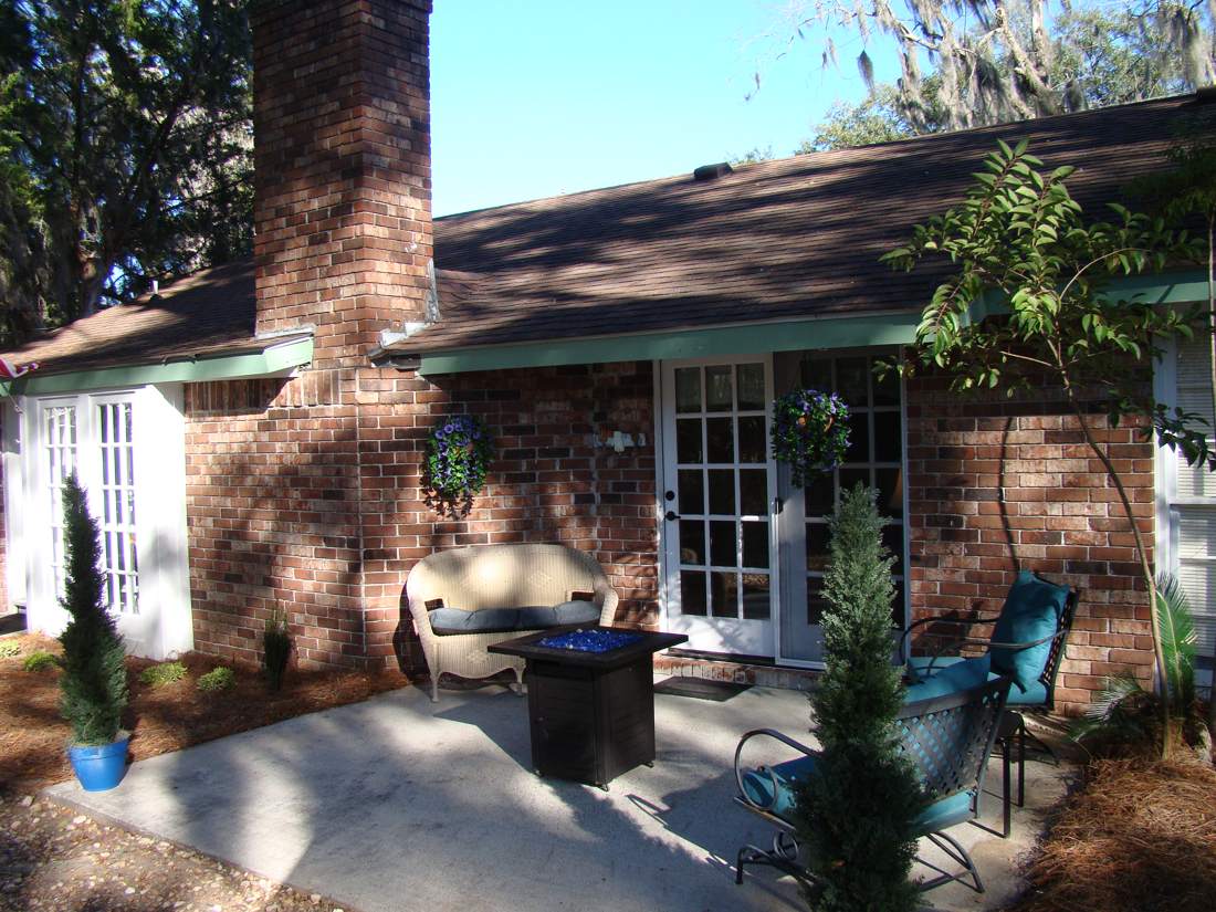 Brick patio with propane fire table, chairs and French doors